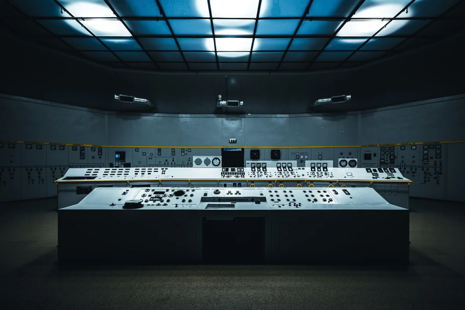 Leerer Leitstand mit großem Kontrollpult – Sinnbild für IT-Monitoring-Tools ohne Besetzung