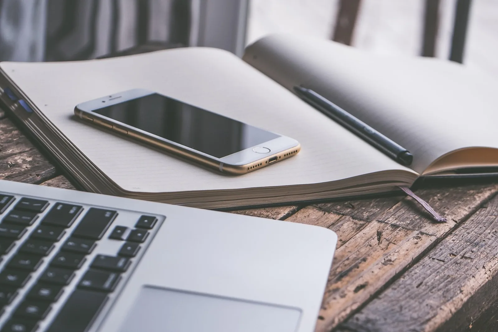 Smartphone und Notebook auf einem Schreibtisch – Geräte, für die viele Firmen MDM-Software kostenlos suchen