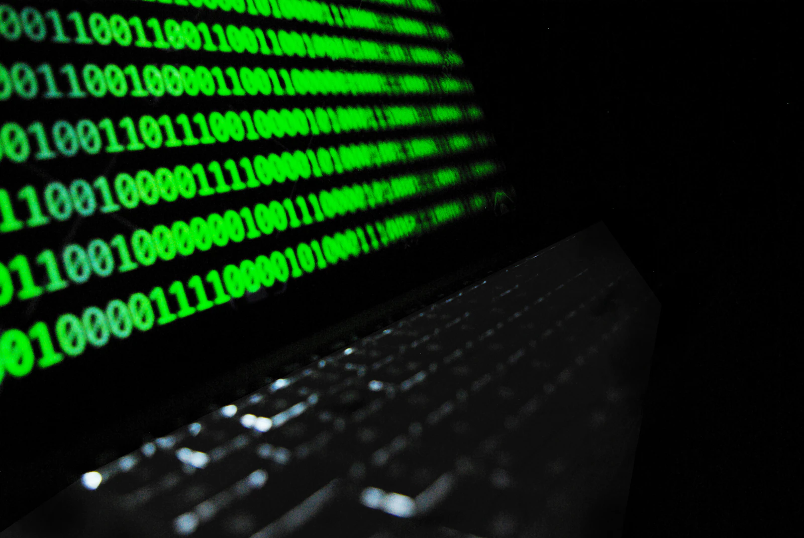 Laptop mit grünem Code-Bildschirm in dunkler Umgebung – Schutz vor Ransomware im Unternehmen